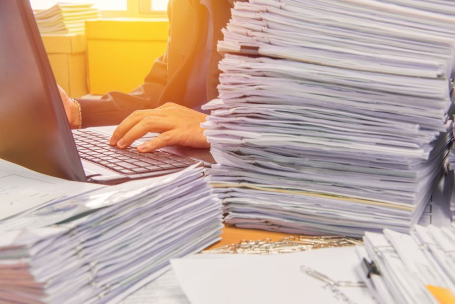 Documents,On,Desk,Stack,Up,High,Waiting,To,Be,Managed.